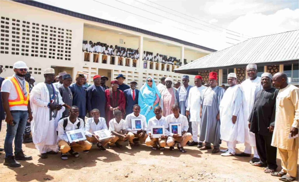 Some student beneficiaries of laptop computers in a group photograph with dignitaries in attendance.